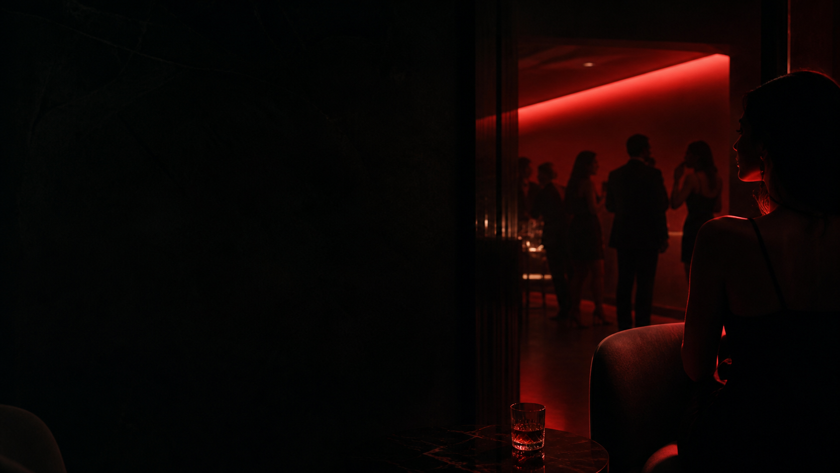 Adult guests socializing in a discreet red-lit lounge